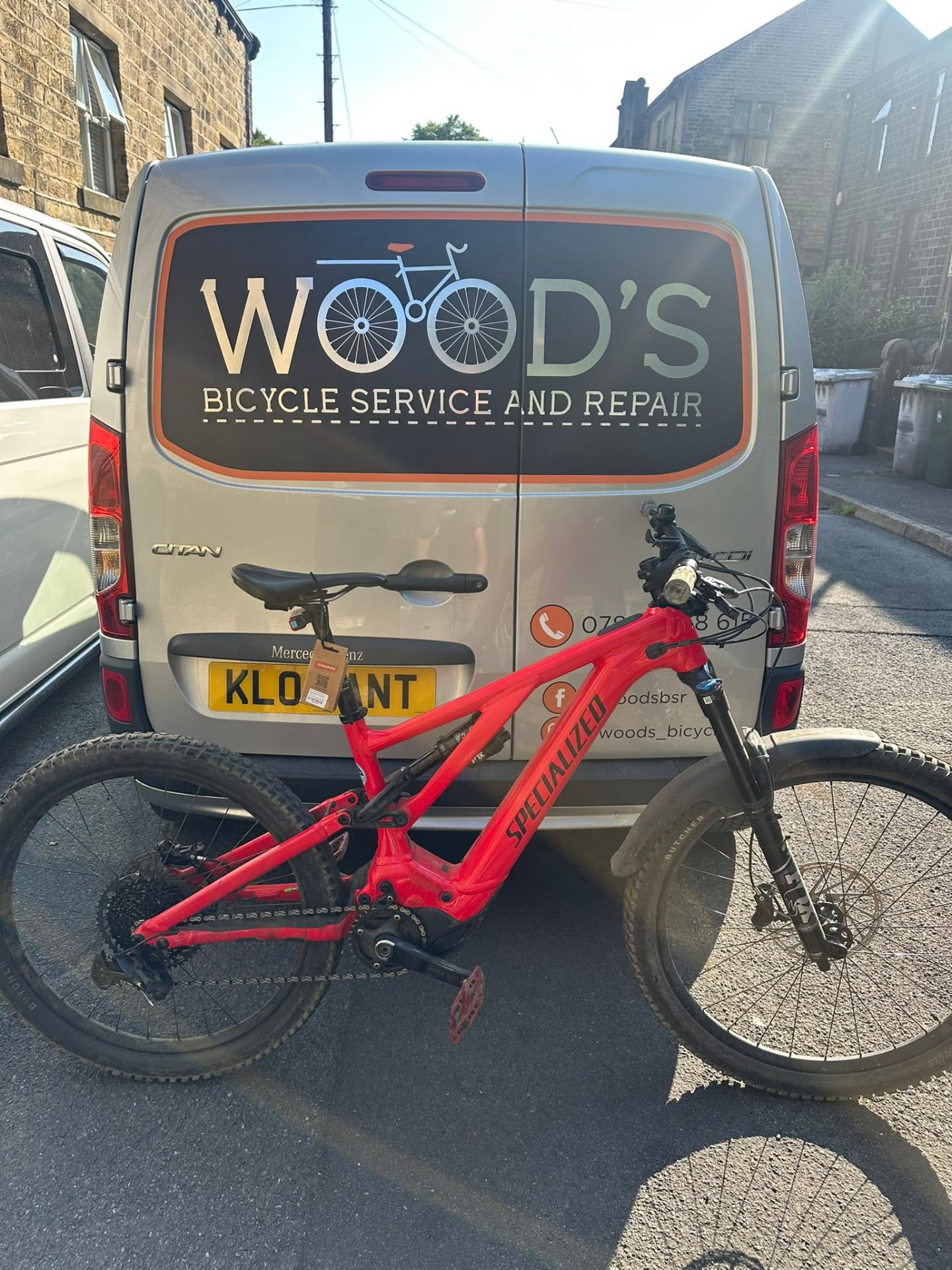 A customer's red Specialized e-bike beside the Wood's van